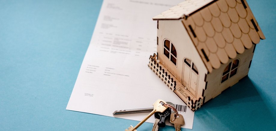Modellhäuschen auf einem Dokument - Symbolbild - Verlinkung zum Immobilien-Preis-Kalkulator